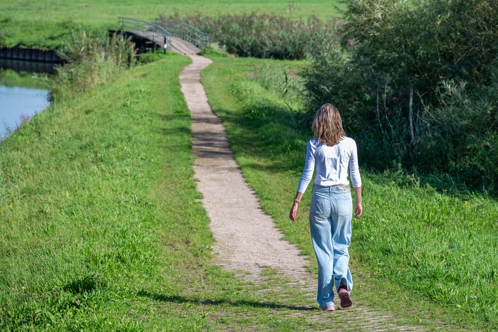 Mirjam wandelend over een pad in de natuur richting rust en balans